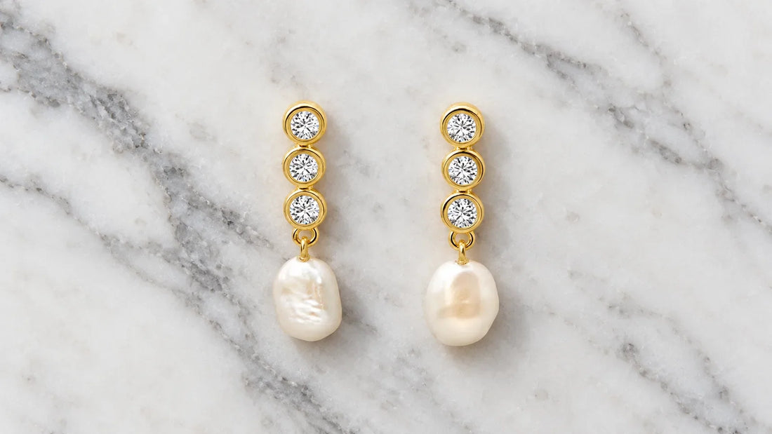 aBaroque Pearl Drop Earrings in gold-plated silver with irregular freshwater pearls on white marble