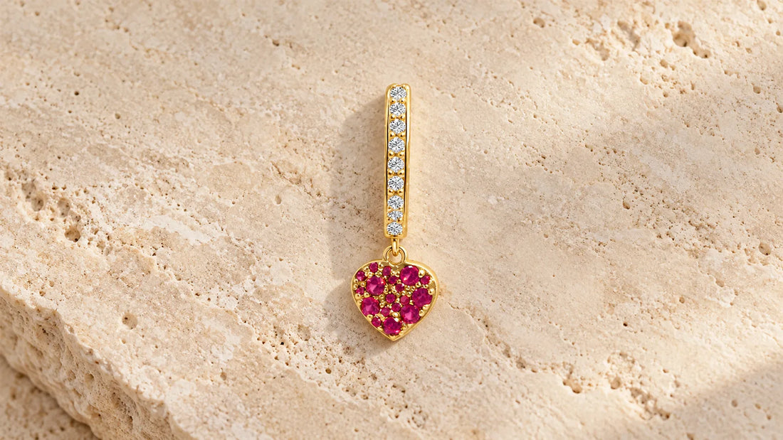 aSymbol Single Hoop in gold-plated silver with a heart of red stones on light travertine stone